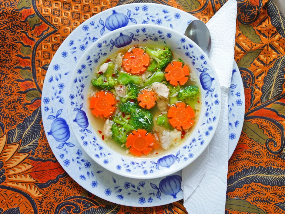 Klare Hühnersuppe mit Brokkoli und Karottenblumen