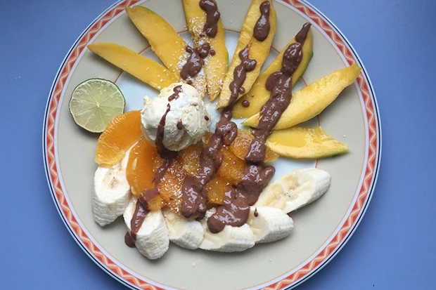 Exotischer Obstsalat mit Eis und heißer Schokolade