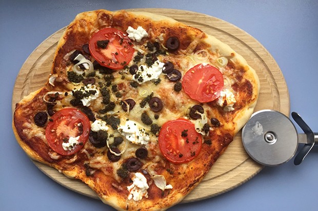 Pizza Rusticana mit Tomaten, Schafkäse, Oliven und Pesto