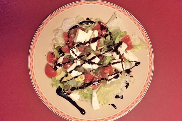 Salatplatte mit Blattsalat, Tomaten, Mozzarella, Avocado und Balsamicoreduktion