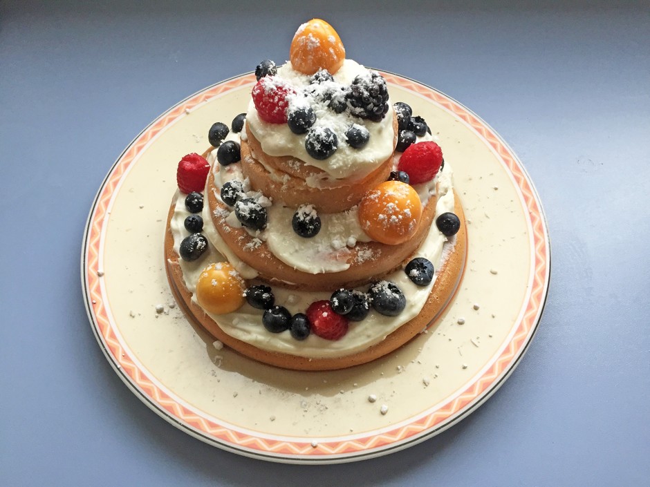 Dreistöckige Biskuittorte mit Beeren und Kokos