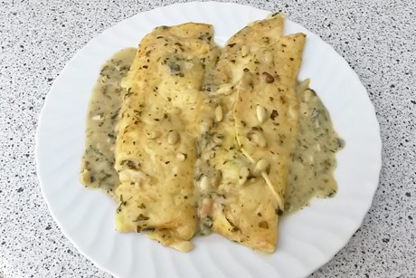 Spinatpalatschinken mit Pinienkernen und Käsesauce