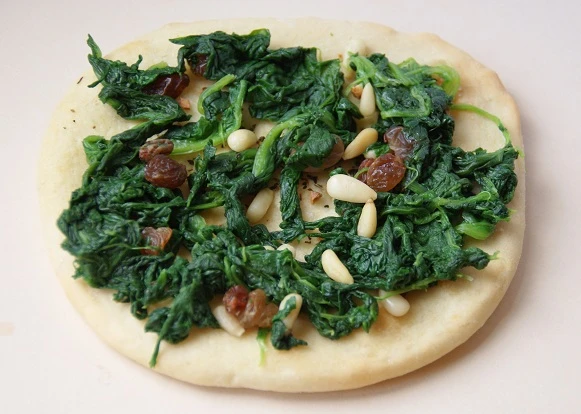Pizza mit Spinat und Pinienkernen