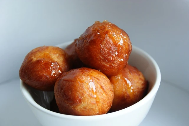 Krosse Krapfen mit Honigsirup und Zimt