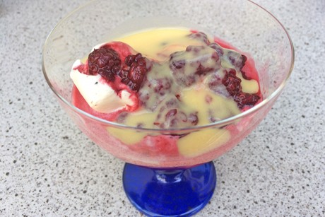 Eisbecher mit heißen Brombeeren und Eierlikör