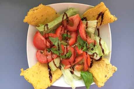 Grüner Salat mit Tomaten und Polentaschnitten