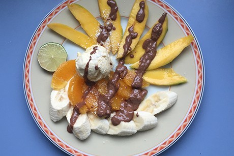 Exotischer Obstsalat mit Eis und heißer Schokolade