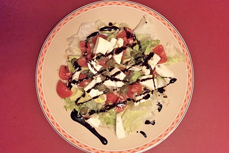 Salatplatte mit Blattsalat, Tomaten, Mozzarella, Avocado und Balsamicoreduktion